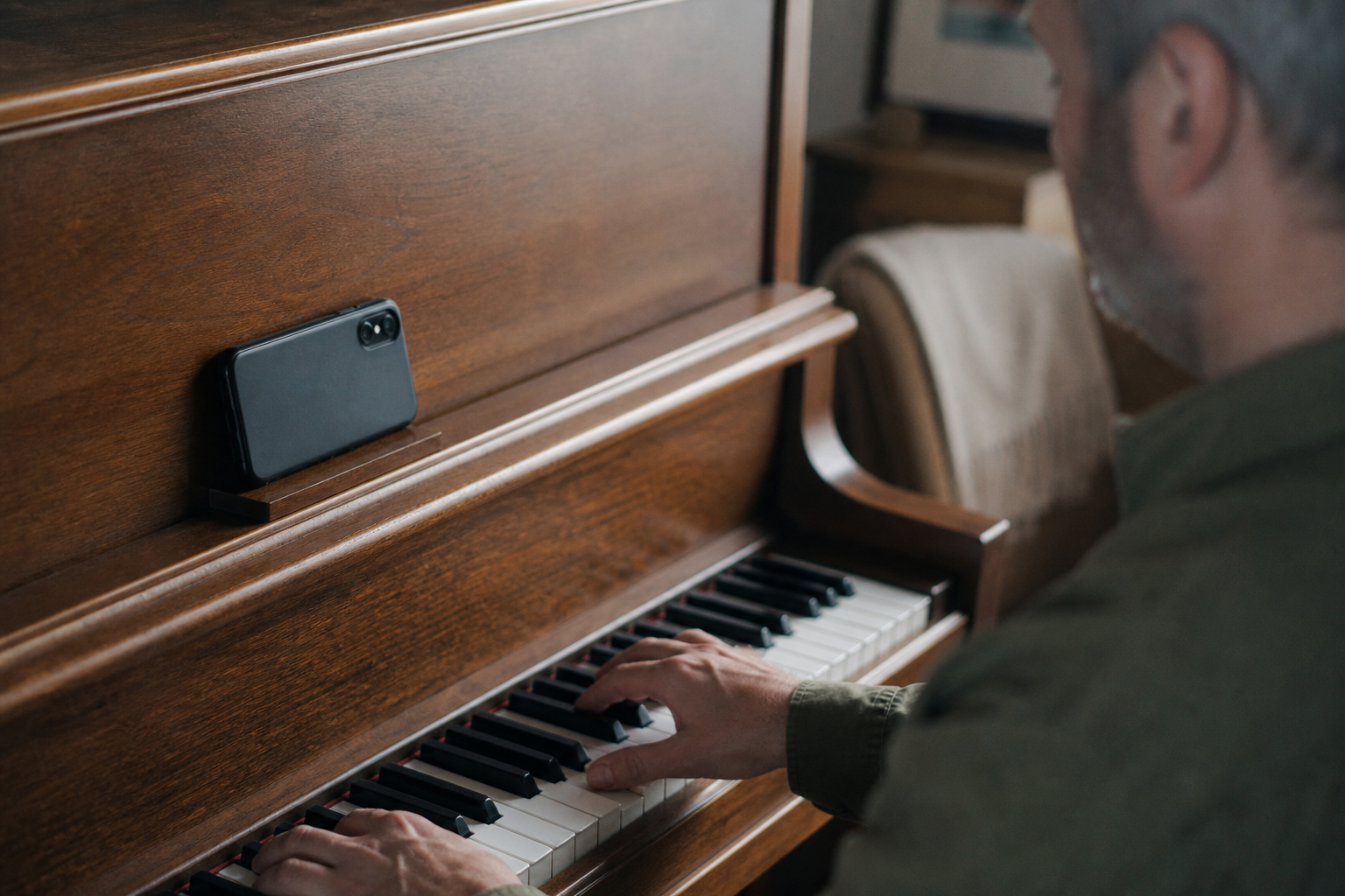Smartphone recording a piano practice session placed on top of the piano, simple home setup